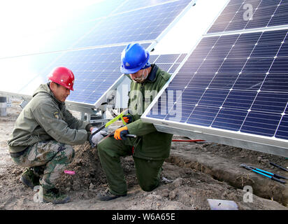 ------ Chinesische Arbeiter installieren Solaranlagen mit einer Photovoltaik- Kraftwerk in China Huaneng Gruppe in Daqing Stadt, im Nordosten Chinas Heilongjiang pro Stockfoto