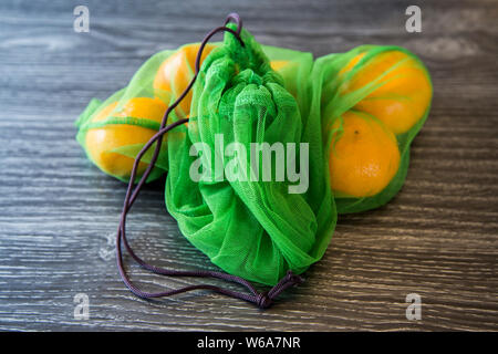 Organische Mandarinen gekauft von lokalen Markt in wiederverwendbaren Taschen produzieren von upcycling Alte single use Plastiktüten. Geben weichen Kunststoff neues Leben Stockfoto