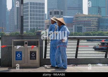 Chinesische Arbeiter schirmt sich mit Hüte von der sengenden Sonne, wie sie Arbeit am Bund in Shanghai, China, 26. Juni 2018. Shanghai wetter Bure Stockfoto