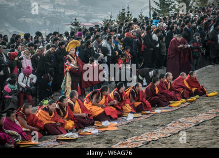 ---- Lamas und Anwohner Blick auf eine riesige Thangka Buddha am Langmu Tempel während der Sho Dun Festival, gemeinhin als Joghurt Fest bekannt Stockfoto