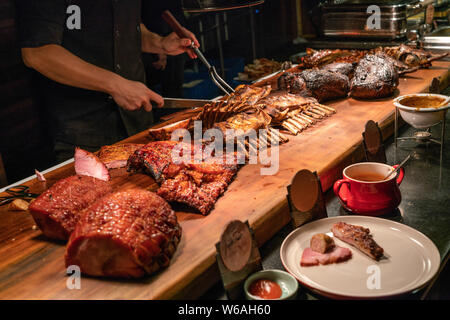 Koch in Fleisch buffet Schneiden köstliche gegrillte Rippen Stockfoto