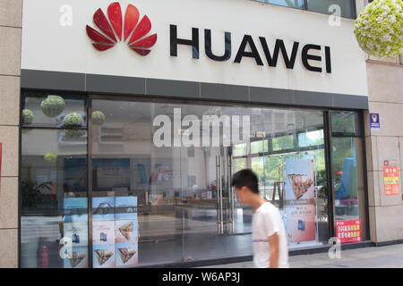 ---- Ein Fußgänger geht hinter einem Store von Huawei in Chongqing, China, 20. Mai 2018. Huawei US-Operationen wurden ein weiterer Schlag in diesem Monat behandelt, wenn Stockfoto