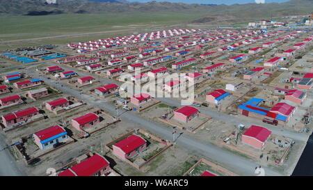 Luftbild der Neuen Residenz der Kasachen in die roten Dächer aufgereiht auf einer Wiese in Yiwu County, Hami Stadt im Nordwesten Chinas Xinjiang Uyghur Autonomou Stockfoto