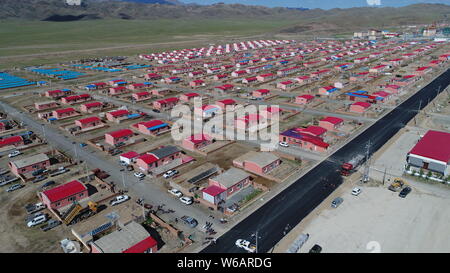 Luftbild der Neuen Residenz der Kasachen in die roten Dächer aufgereiht auf einer Wiese in Yiwu County, Hami Stadt im Nordwesten Chinas Xinjiang Uyghur Autonomou Stockfoto