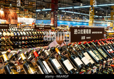 Ein ausländischer Kunde Geschäfte für Rotwein aus Frankreich an der U-Supermarkt in Shanghai, China, 12. Juni 2018 eingeführt. China kündigt eine Reihe von in Stockfoto