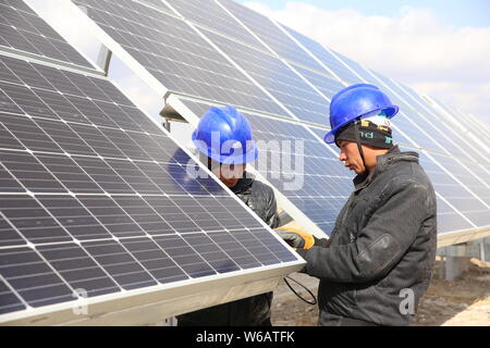 ------ Chinesische Arbeiter installieren Solaranlagen mit einer Photovoltaik- Kraftwerk in China Huaneng Gruppe in Daqing Stadt, im Nordosten Chinas Heilongjiang pro Stockfoto