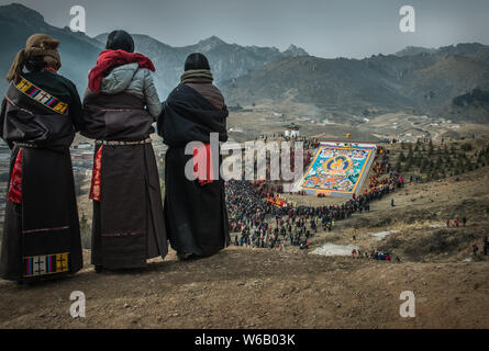 ---- Lamas und Anwohner Blick auf eine riesige Thangka Buddha am Langmu Tempel während der Sho Dun Festival, gemeinhin als Joghurt Fest bekannt Stockfoto