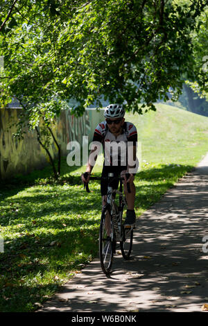 Ein Mann fährt mit dem Fahrrad auf dem Rivergreenway Trail in Fort Wayne, Indiana, USA. Stockfoto