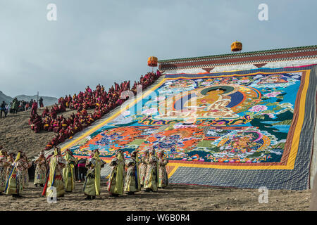 ---- Lamas und Anwohner Blick auf eine riesige Thangka Buddha am Langmu Tempel während der Sho Dun Festival, gemeinhin als Joghurt Fest bekannt Stockfoto