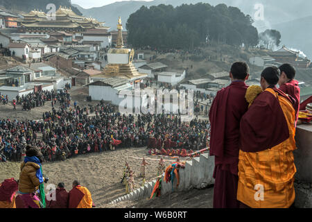 ---- Lamas und Anwohner Blick auf eine riesige Thangka Buddha am Langmu Tempel während der Sho Dun Festival, gemeinhin als Joghurt Fest bekannt Stockfoto