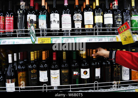 --FILE - ein chinesischer Kunde Geschäfte für importierte Rotwein in einem Supermarkt in Zouping County in der ostchinesischen Provinz Shandong, 24. März 2018. China wird Stockfoto