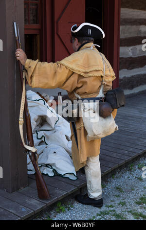 Ein reenactor mit einer Muskete porträtiert ein Jäger aus dem 18. Jahrhundert im historischen Fort Wayne in Fort Wayne, Indiana, USA. Stockfoto
