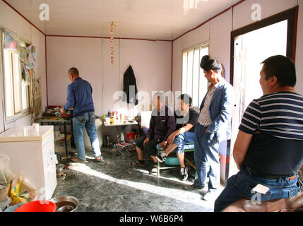 Chinesische Wanderarbeiter sind dargestellt in einem eisernen Kasten in der Mitte des National Highway 109 über unbezahlte Löhne für vier Jahre in Lanzhou zu protestieren Stockfoto