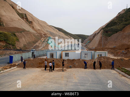 Chinesische Wanderarbeiter heben Sie den Graben in der Nähe der eisernen Kasten Häuser in der Mitte des National Highway 109 über unbezahlte Löhne für vier Jahre zu protestieren Stockfoto