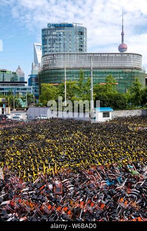 Verlassene Fahrräder der Chinesischen bike-sharing Dienste werden auf einem Parkplatz in der Nähe des Bund in Shanghai, China, 11. Mai 2018 aufgetürmt. Stockfoto