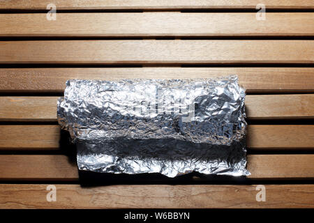 Aluminiumfolie auf hölzernen Hintergrund Stockfoto