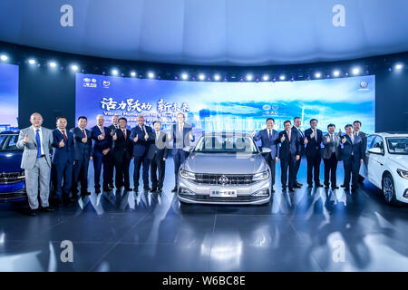 Jochem Heizmann, Mitte links, Chief Executive Officer und Präsident der Volkswagen Group China, Xu Liuping, Mitte rechts, Vorsitzender der FAW Group Corp., Stockfoto