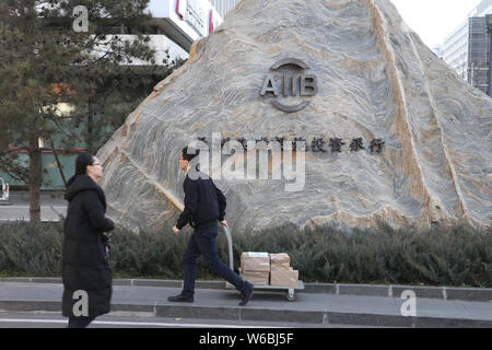 ---- Fußgänger vorbei an den Hauptsitz der Asiatischen Infrastruktur Investitionsbank (AIIB) in Peking, China, 11. Dezember 2017. Die asiatische Inf Stockfoto