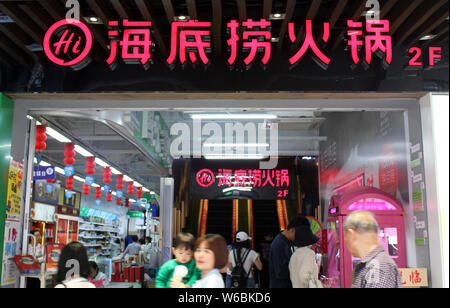 ---- Fußgänger vorbei ein hotpot Restaurant von Hai Di Lao, in Xiamen Stadt im Südosten der chinesischen Provinz Fujian, 21. April 2018. Haidilao Internati Stockfoto