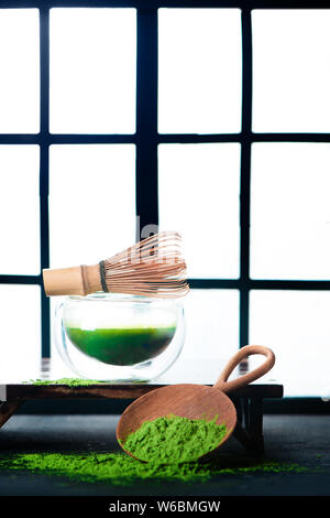 Matcha grüner Tee in eine doppelte Wand Glas Tee Schüssel mit einem Bambusbesen. Shoji Schiebetüren Hintergrund, traditionelle Japanische Zeremonie Stockfoto