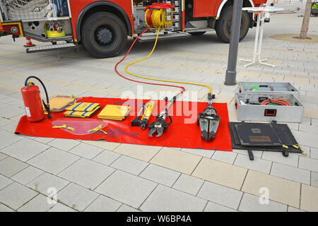 Tools wie Brandbekämpfung Löschmittel Decke, hydraulische Rettungs Cutter oder Feuerlöscher von fire truck auf Anzeige auf rot Decke auf dem Boden Stockfoto