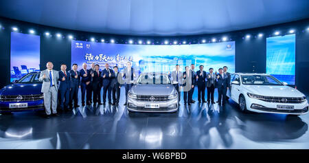 Jochem Heizmann, Mitte links, Chief Executive Officer und Präsident der Volkswagen Group China, Xu Liuping, Mitte rechts, Vorsitzender der FAW Group Corp., Stockfoto