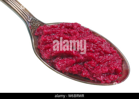 In der alten goldenen Löffel gibt es einen kleinen Haufen von Essen - Heiße geriebener Meerrettich Sauce mit Rote-Bete-Saft. Auf weissem studio Makro isoliert Stockfoto