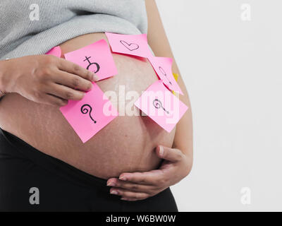 Körperteil schwangeren Bauch mit rosa Haftnotizen auf weißem Hintergrund. Stockfoto