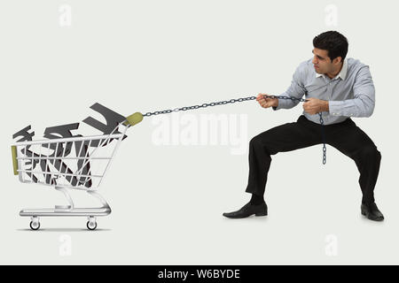 Mann schleppt Rupie-Symbole in einen Warenkorb Stockfoto