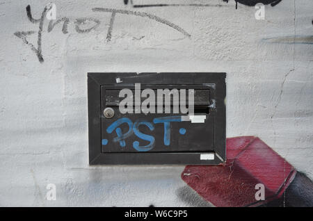 Schwarz Briefkasten auf der weißen Wand mit Graffiti Stockfoto