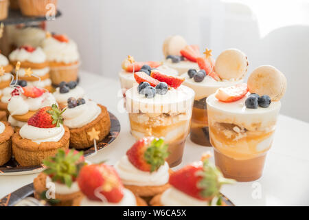 Candy Buffet mit White souffle in Gläser. süßen Buffet mit Kuchen, Tiramisu Gläser und andere Desserts. Obst Kuchen für Urlaub. Candy Bar Stockfoto