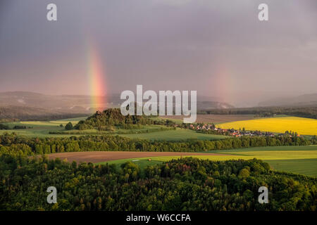 Dunkle Gewitterwolken und ein Regenbogen über die Felsformationen der Sächsischen Schweiz Stockfoto