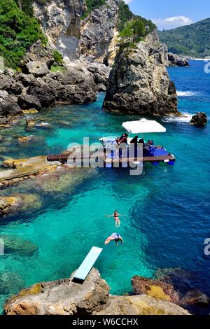 Ein Mann Tauchen ins Meer, La Grotta Beach Bar, Paleokastritsa, Korfu, Griechenland Stockfoto