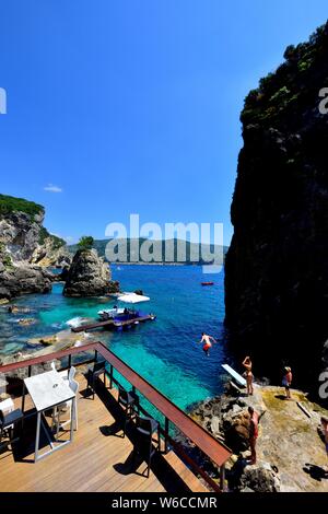 Ein Mann Tauchen ins Meer, La Grotta Beach Bar, Paleokastritsa, Korfu, Griechenland Stockfoto