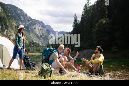 Lächelnden jungen Menschen die Natur geniessen neben Zelten und Unterhaltung im Freien Stockfoto