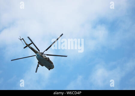 Militärische Hubschrauber im Flug auf dem Hintergrund der blauen Himmel mit weißen Wolken. Ansicht von unten, luftwaffen Konzept Stockfoto