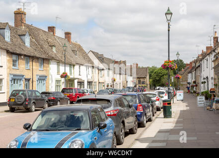 Autos auf Straßenfront geparkt außerhalb der historischen Gebäude in der sächsischen Stadt Cricklade, Wiltshire, England, Großbritannien Stockfoto