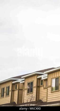 Vertikale Fassade der Häuser mit Nahaufnahme des Obergeschosses gegen bewölkter Himmel Stockfoto