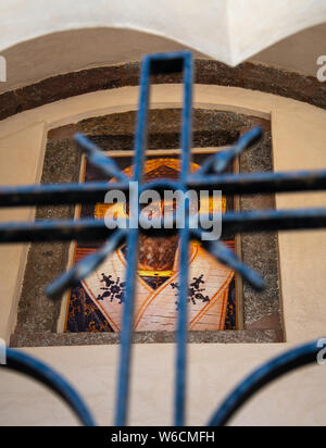 Emporio, Griechenland - 14. Juli 2019: Die Augen des 15. Jahrhunderts Fresko des Heiligen Spyridon durch die Mitte der Kirche Kreuz geformten Eisernen Tor gesehen Ich Stockfoto