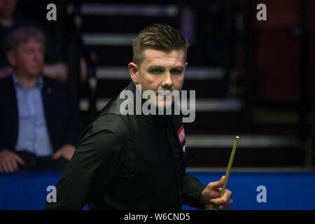 Ryan Tag der Wales vertritt einen Schuß zu Anthony McGill von Schottland in ihrer ersten Runde während der 2018 Betfred World Snooker Championship an der Stockfoto