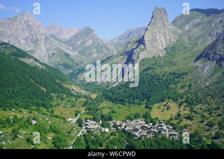 LUFTAUFNAHME. Letztes Dorf (alt.: 1650m) des oberen Maira-Tals und dessen markante 'Rocca Provenzale' (alt.: 2451m). Chiappera, Piemont, Italien. Stockfoto
