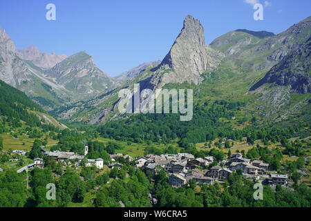 LUFTAUFNAHME. Letztes Dorf (alt.: 1650m) des oberen Maira-Tals und dessen markante 'Rocca Provenzale' (alt.: 2451m). Chiappera, Piemont, Italien. Stockfoto