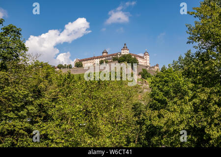 Das Schloss Festung Marienberg liegt auf einem Hügel oberhalb der Stadt, durch die Bäume gesehen entfernt Stockfoto