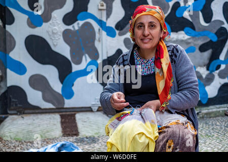 Portrait von eine türkische Frau mit Kopftuch Nähen auf der Straße vor ihrem Haus in Istanbul, Türkei Stockfoto