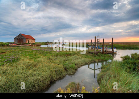 Moody Sonnenaufgang am alten Hafen von Thornham in der Nähe von Hunstanton an der nördlichen Küste von Norfolk Stockfoto