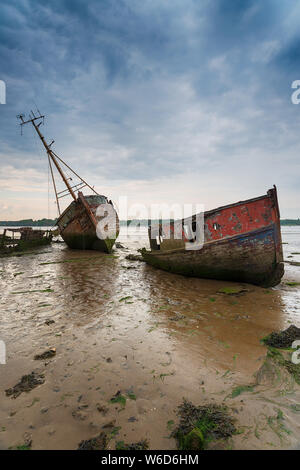 Abgebrochene Fischerboote unter ein Brütendes sky Stockfoto