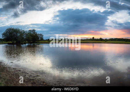 Stürmische Sonnenuntergang über Janesmoor Teich an Fritham im New Forest in Hampshire Stockfoto