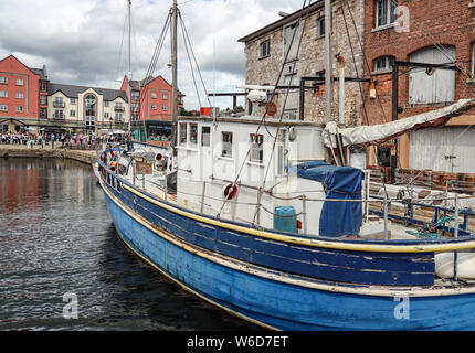 Boot von alten Gebäuden angedockt auf der Wasserseite an der Exeter Quays. Exeter, die Hauptstadt der Grafschaft von Devon und historische Domstadt. Stockfoto