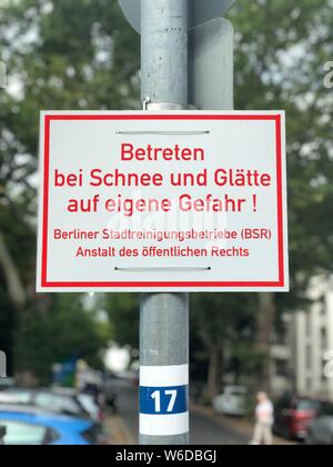 Schild. Text in Deutsch: Geben Sie durch Schnee und Eis auf eigene Gefahr Stockfoto