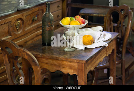 Obst, Wein Glas und Flasche Anordnung mit antiken Möbeln im Studio von French Post-Impressionist Künstler Paul Cézanne in Aix-en-Provence, Prov Stockfoto